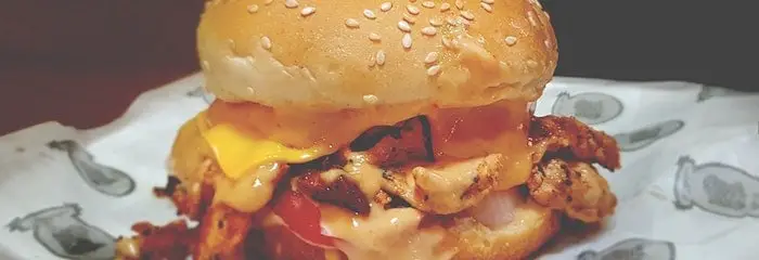 Unhealthy cheeseburger on a dinner plate.
