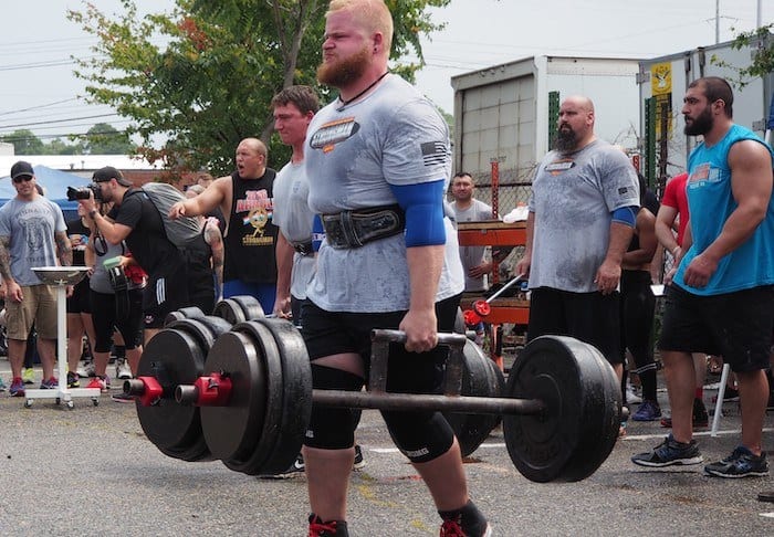 Large man doing a farmers walk with a lot of weight.