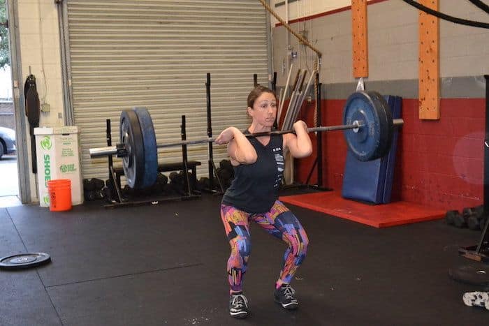 Woman doing a power clean with four plates.