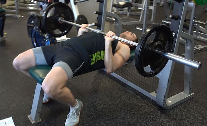 Weightlifter bench pressing with a close grip.