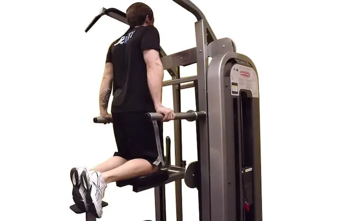 Man using a dip machine, which targets the triceps.