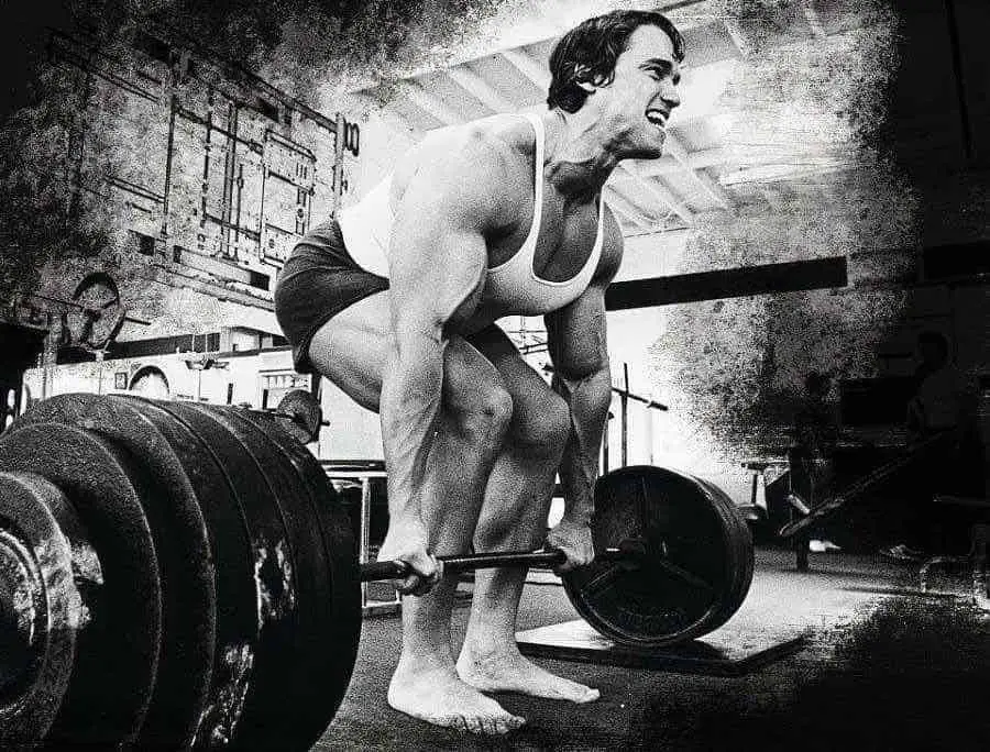 Arnold Schwarzenegger lifting weights while barefoot.