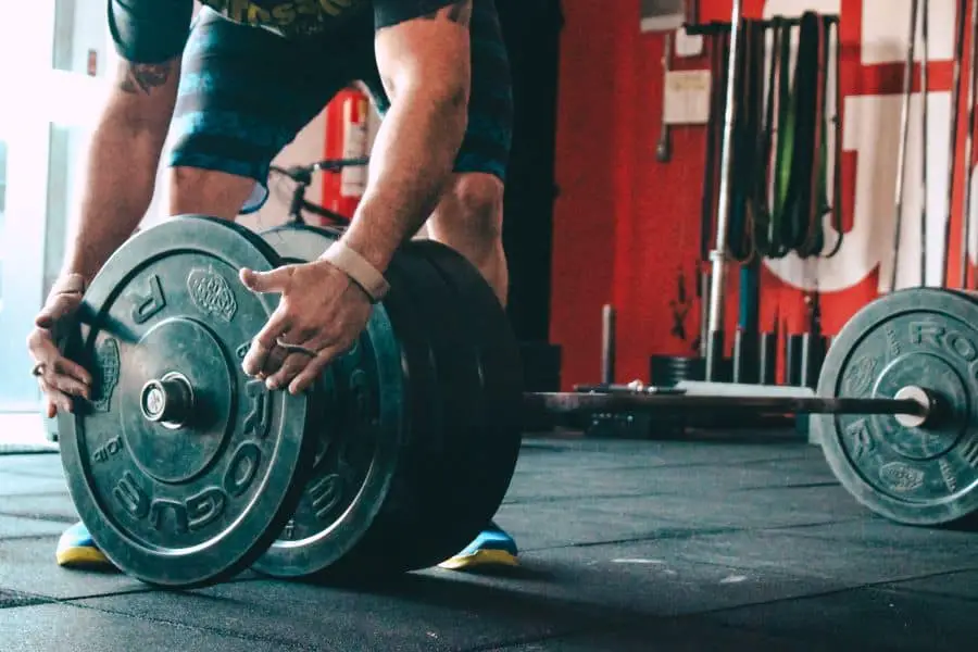 Man loading plates onto a barbell.