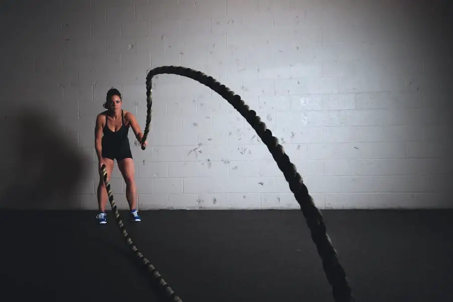 Woman doing battle ropes, a workout that uses creatine.