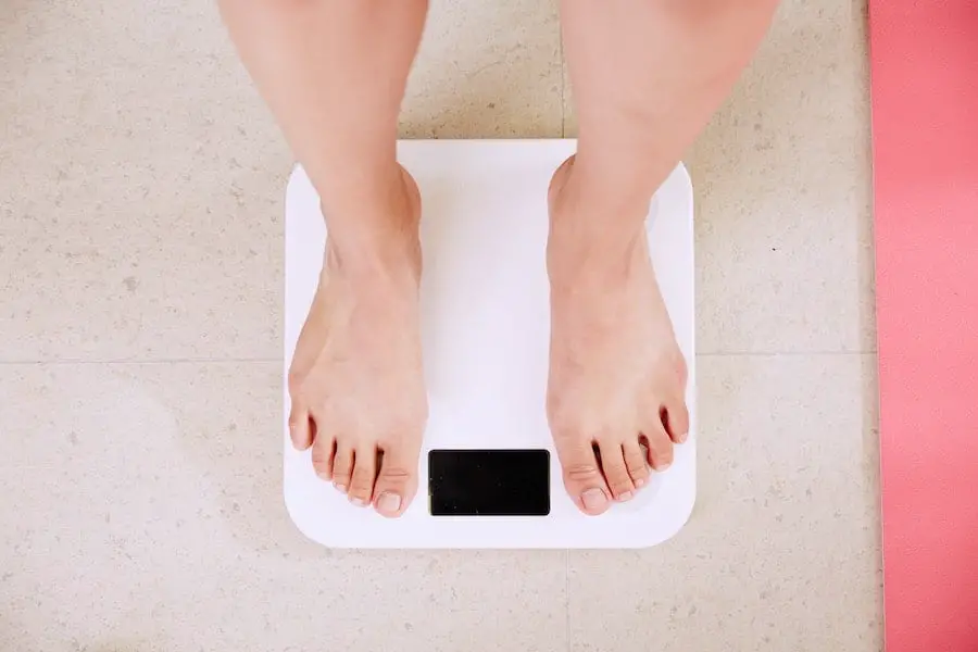 Woman checking her weight on a bathroom scale.