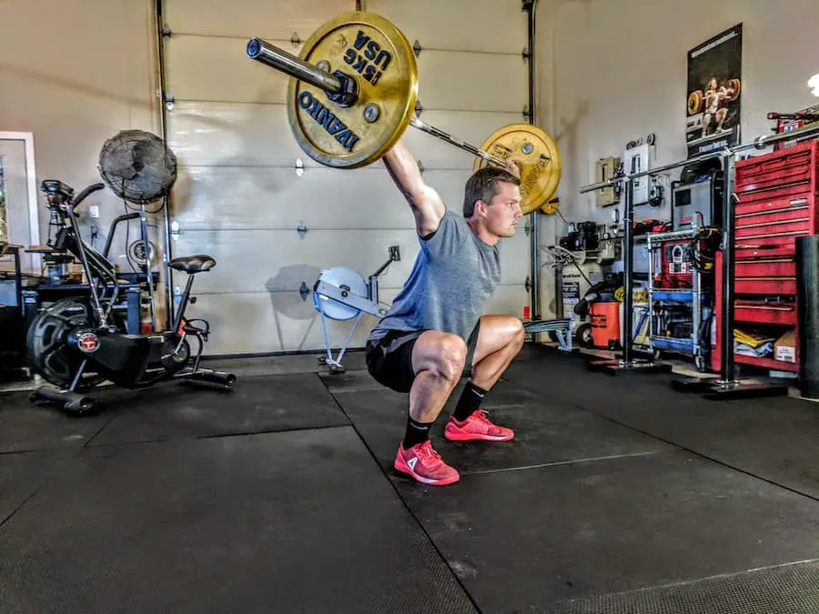 Man lifting a barbell above his head.