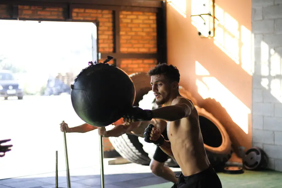 Man building muscle by using a punching bag.