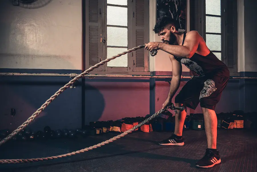 Man using battle ropes to build muscle.