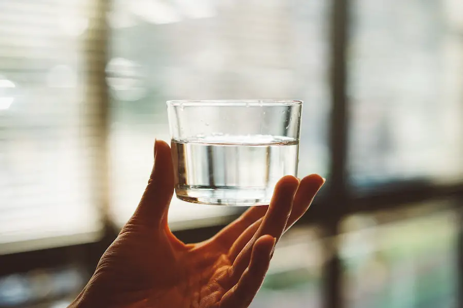 Person holding a glass of water.